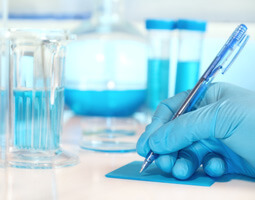 A scientist writing in a lab notebook